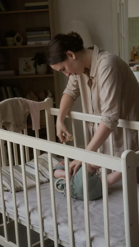 Mother Putting Crying Infant to Sleep in Crib at Home Stock Footage 346611219