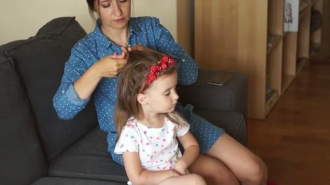 Mother putting daughters hair in pigtails. A happy family. Mothers Day. Women's Stock Footage