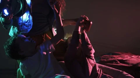 Mother putting VR headset on boy in colored lights Stock-Footage 103638838