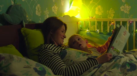 Mother Reading a Book to Son before Sleep Stock Footage 56722343