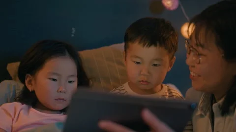 Mother Reading with Children on Tablet Before Bedtime Stock Footage 321076542