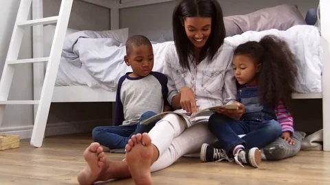 Mother Reading Story To Children In Their Bedroom Stock Footage
