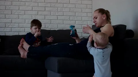 Mother Rest on a Couch While Her Sons Playing Around Stock Footage 62505232