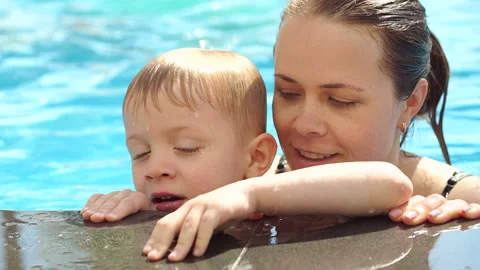 Mother is resting with her son in the pool. Portrait of mother and son in pool. Stock Footage 120107070