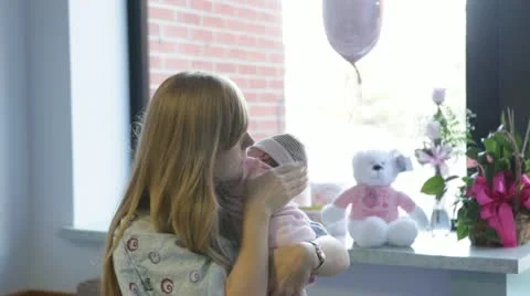 Mother rocking newborn while standing in birthing room Stockbeeldmateriaal 12082429