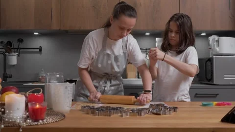 Mother rolling out dough while her child cleans their sticky, messy hands. Stock Footage 311807114