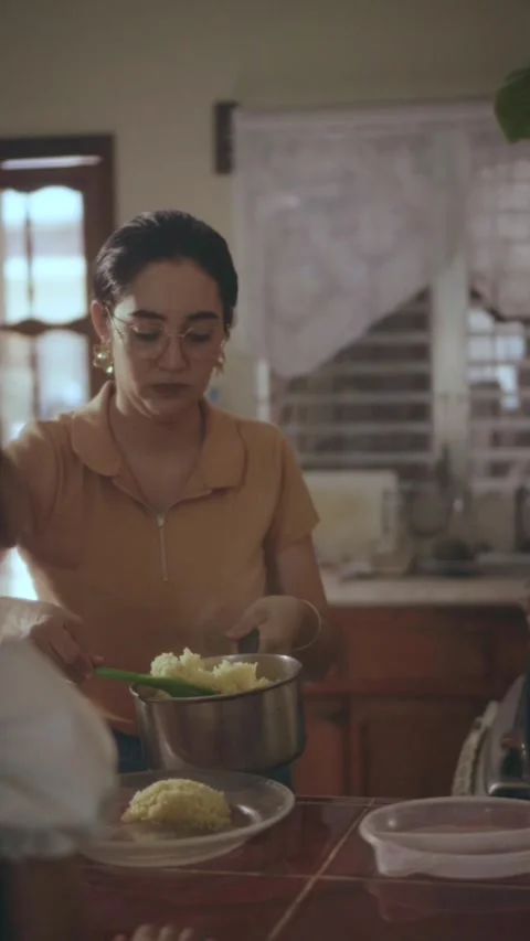 Mother serving dinner in a warm kitchen Vidéo 341893083