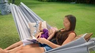 Mother Sits With Daughter In Hammock Stock Footage