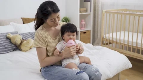 Mother sitting at bedside watching her child Video stock 156920430