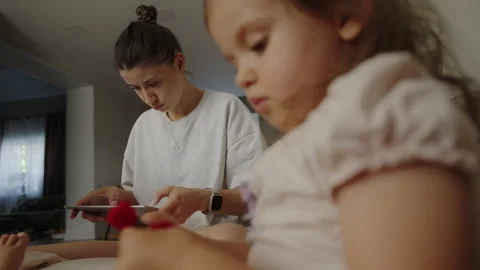 Mother sitting on the couch next to her children, using the tablet. Close Stock Footage 252172303