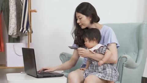Mother sitting with her kid typing on computer Video stock 149592174