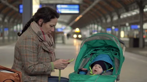 Mother sitting on station and using phone  Stock Footage 60663388