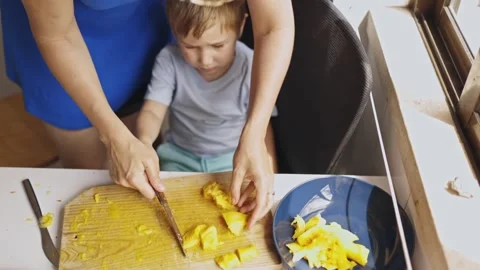 Mother slicing fresh fruit for son Stock Footage 319419356