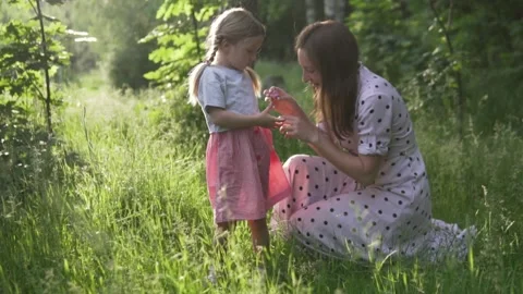 A mother with a small child is walking in the woods at sunset Stock Footage 132914341