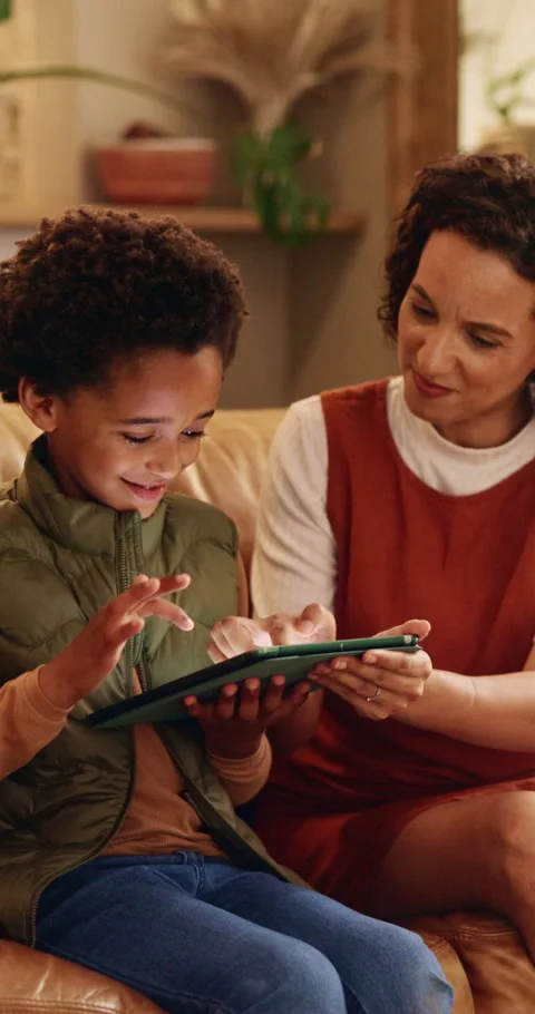 Mother, son and tablet on sofa for elearning, bonding and educational app in Stock Footage 343229595