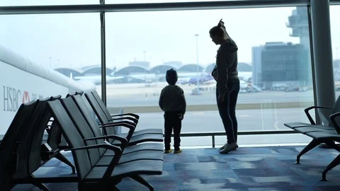 Mother with son looking at the planes through window in airport. Loving family Видео 107139982