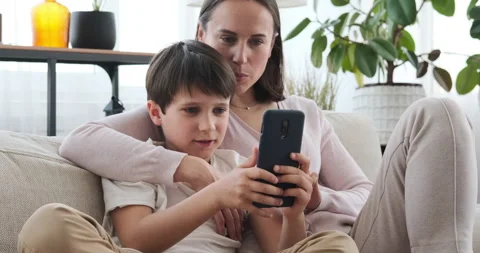 Mother with son using mobile phone on sofa at home Video stock 133202389