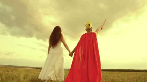 Mother son walk through green field sunset. child teenager plays superhero Stock Footage 233684008