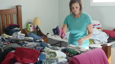 Mother sorting through her kids clothes Stock Footage 56503070