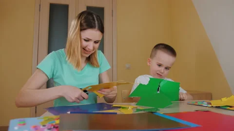 Mother spending time with son, making application, child cutting colored paper Stock-Footage 186047899