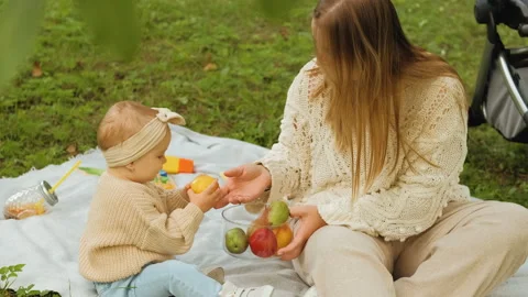 Mother spends time with her young daughter outdoors in the park, young mom Stock Footage 234317899