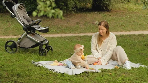 Mother spends time with her young daughter outdoors in the park, young mom plays Stock Footage 234319177
