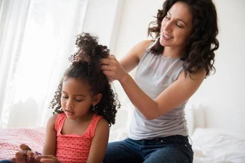Mother styling hair of daughter Stock Photos