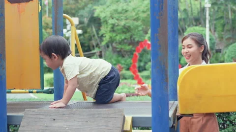 Mother supporting her son while playing on equipment. Stock Footage 204967065