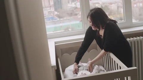 Mother takes newborn son from bed Stock Footage 87205802