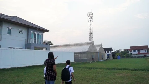 Mother taking hand of sons walking from house go to school together Stockbeeldmateriaal 100944102