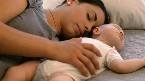Mother taking a nap with her sleeping baby. 库存影片 88370292