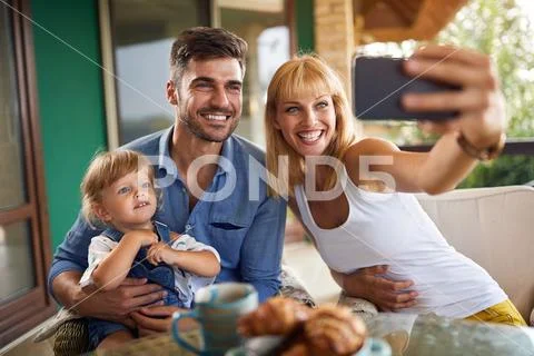 Mother taking photos with daughter and husband Stock Photos