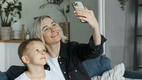 Mother taking selfie with boy using mobile phone. Woman and child Stock Footage 156808334