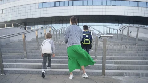 Mother taking two schoolboys to school. Parent's school day routine. Back to Stock Footage 140083763