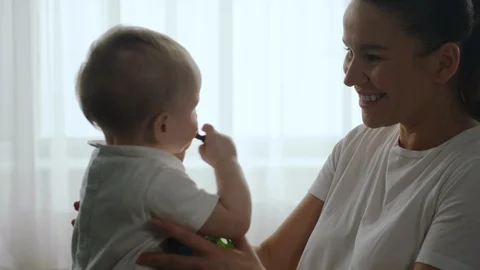 Mother talking and playing with her baby at home Stock Footage 104711087