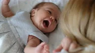 Mother Talking And Playing With Newborn Baby Girl. Maternity And Family Concept Stock Footage