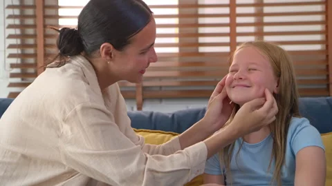 Mother talking and touch of face her daughter while sitting together Vídeo Stock 340143871