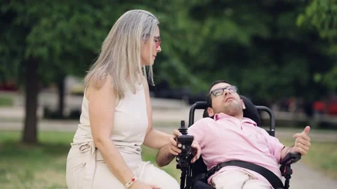 Mother talking with son with a physical disability in a wheelchair Stock Footage 341256708