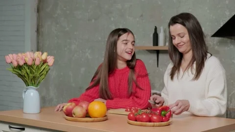 Mother talks to her daughter while she prepares the vegetable salad. Stock Footage 150829665