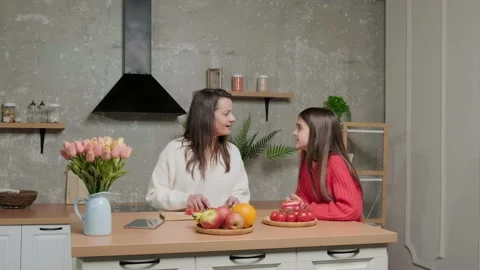Mother talks to her daughter while she prepares the vegetable salad. Video stock 151481248