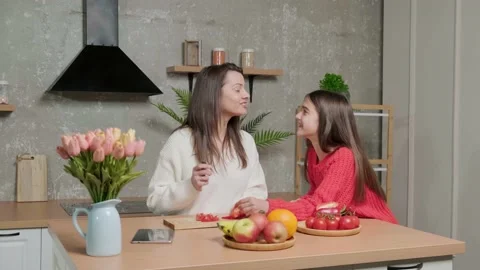 Mother talks to her daughter while she prepares the vegetable salad. Stock Footage 155761676