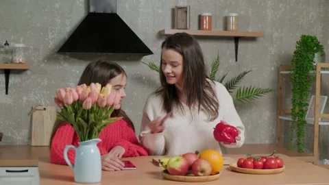 Mother talks to her daughter while she prepares the vegetable salad. Stock Footage 155810322