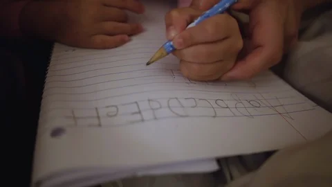 Mother teaching daughter how to write the alphabet Stockbeeldmateriaal 123157532