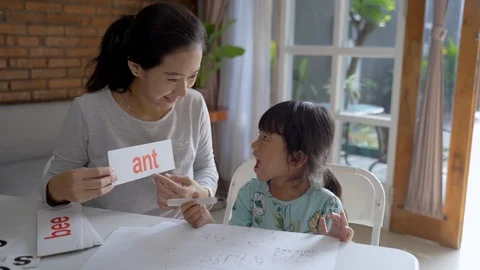 Mother teaching her daughter the basic to read and write Stock Footage 117412667