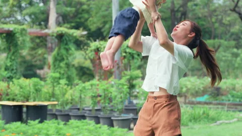 Mother teasing and throwing her little son in park. Stock Footage 204007031