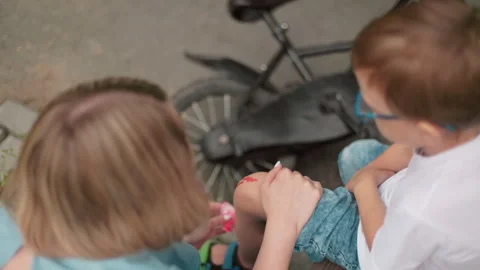 Mother Tends to Son's Bleeding Leg After Bicycle Accident Stock Footage 288729680