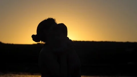 Mother throws up baby playing at sunset. Slow motion. Video stock 79332425