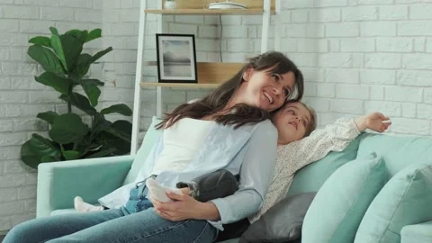 Mother tickling her daughter while they play together on the sofa. Stock Footage 168530406