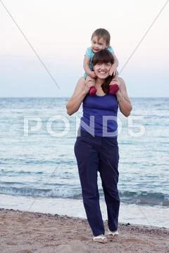 Mother with toddler walking on beach Stock Photos
