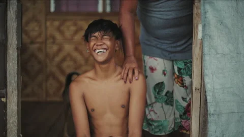Mother touching her smiling son's shoulder Stockbeeldmateriaal 334393136